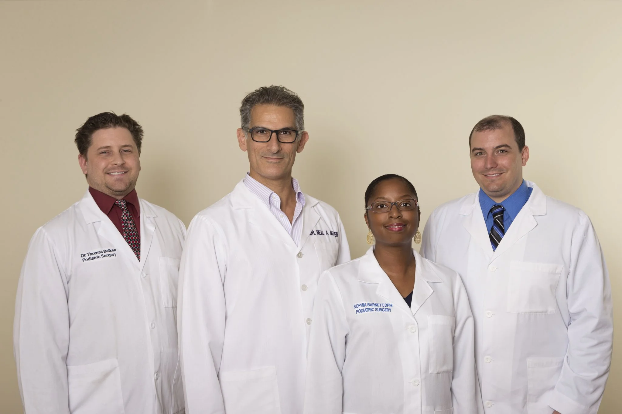 Four podiatrists in white coats standing together at Foot Healthcare Associates